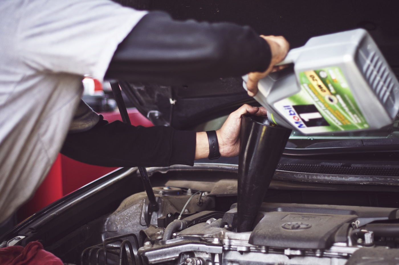 Mechanic checking engine oil in a vehicle